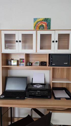 a desk with a printer and a laptop on it at Miuti Residence in Triberg