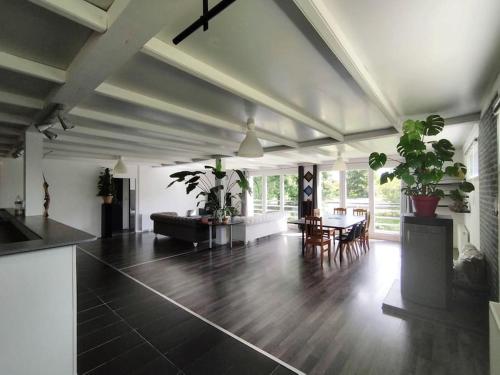 a large living room with a table and chairs at Spacieux loft pour 10 pers ! in Briec