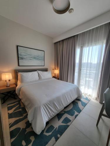 a bedroom with a large bed and a large window at Vida Marina marassi hotel apartment with extra fees for beach or pool access شقة فندقية عائلات فقط في أوتيل فيدا مراسي مارينا دخول شاطئ البحر او حمام السباحة برسوم إضافية in El Alamein