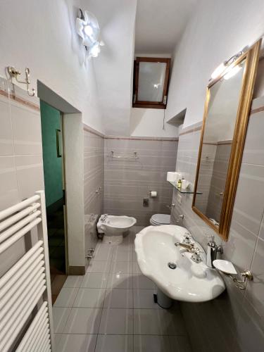a bathroom with a sink and a toilet and a mirror at Le Viole in San Gimignano