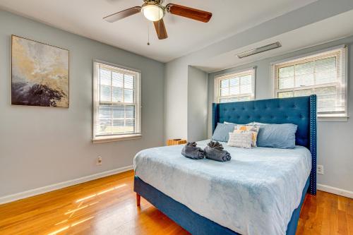 a bedroom with a blue bed with a ceiling fan at Spacious Home with Hot Tub, 14 Mi to Downtown ATL! in Union City