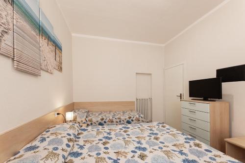 a bedroom with a bed and a flat screen tv at Camping Bungalow Lido in Capoliveri