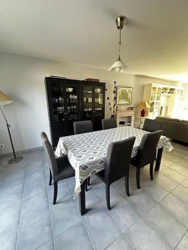 a dining room table with chairs and a table and a table and chairsktop at Bois joli - Maison classée 3 étoiles, à 2 pas de la plage in Langrune-sur-Mer