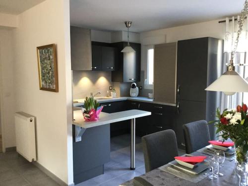 a kitchen with a table and a dining room at Bois joli - Maison classée 3 étoiles, à 2 pas de la plage in Langrune-sur-Mer
