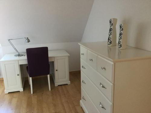 a bedroom with a desk and a table and a chair at Bois joli - Maison classée 3 étoiles, à 2 pas de la plage in Langrune-sur-Mer