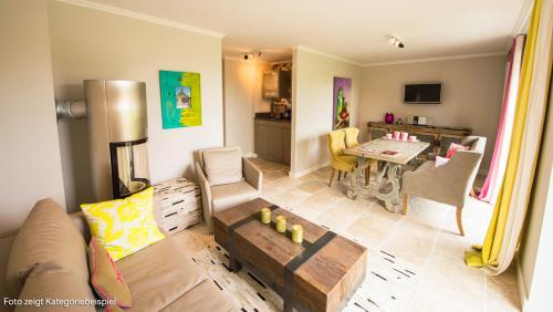 a living room with a couch and a table at Hotel Hof Galerie in Morsum