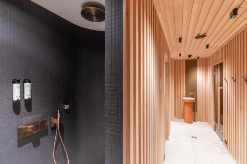 a bathroom with black tiles and a black wall at Sunstar Pontresina in Pontresina