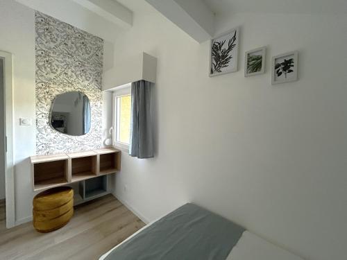 a bedroom with a bed and a mirror on the wall at Gîte des 4 saisons in Rupt-sur-Moselle