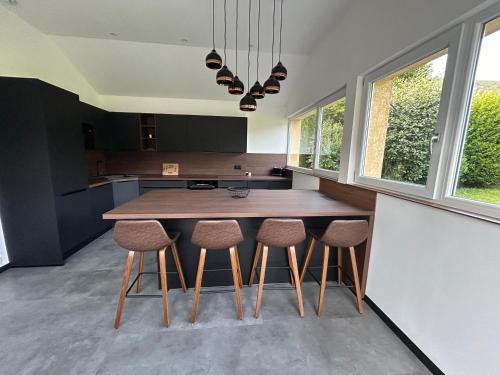 a kitchen with a wooden table and stools at Gîte des 4 saisons in Rupt-sur-Moselle
