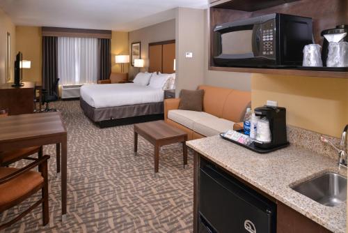 ein Hotelzimmer mit einem Bett und einem Wohnzimmer in der Unterkunft Holiday Inn Express & Suites Page - Lake Powell Area, an IHG Hotel in Page