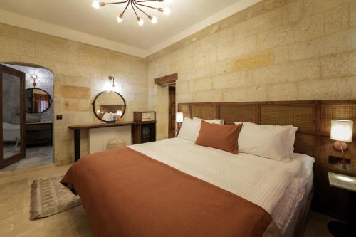 a bedroom with a large bed and two mirrors at Henna Hotel-Adults Only in Goreme