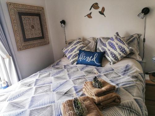 a bedroom with a bed with a blue and white comforter at Aqua View, New Brighton Beach - 1 bedroom with BALCONY & VIEW in New Brighton