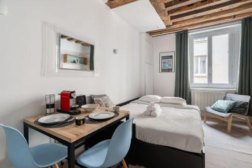 une chambre avec un lit, une table et des chaises dans l'établissement Studio en plein Coeur du Marais, à Paris