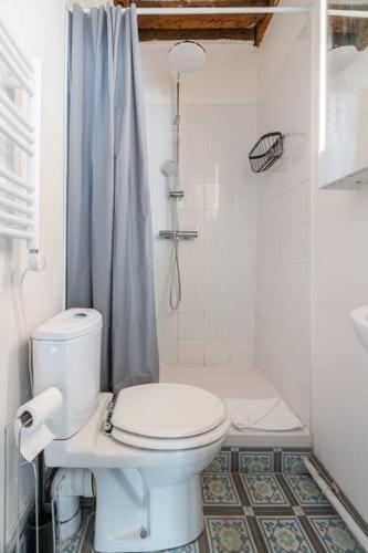 une salle de bain blanche avec toilettes et douche dans l'établissement Studio en plein Coeur du Marais, à Paris