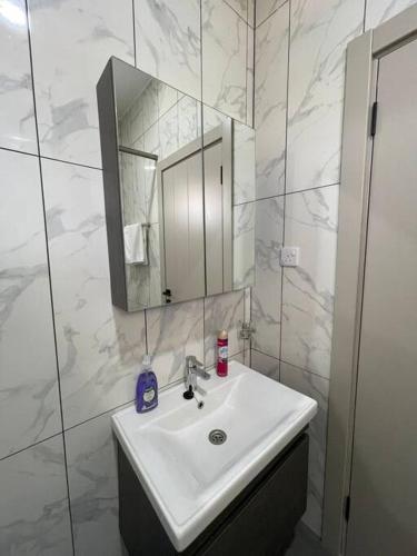 a white bathroom with a sink and a mirror at New Luxe 3 BR oceanview Nyali in Bamburi