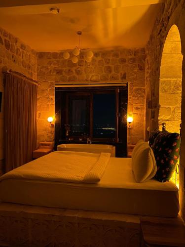 a bedroom with a large bed with a window at Şems inn hotel in Mardin