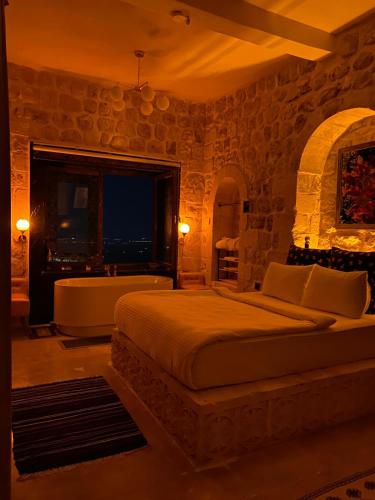 a bedroom with a bed and a stone wall at Şems inn hotel in Mardin