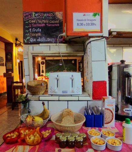 a table with bowls of food and baskets of food at Puerta Azul Hostel in Capilla del Monte