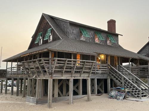 a large house with a gambrel roof on the beach at NH325 Frank Wood Cottage c. 1923 in Nags Head