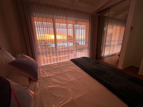 a bedroom with a bed and a large window at Oceanview 3-Bedroom Villa with Garden, Deck, Full Kitchen & WiFi in Halletts Cove