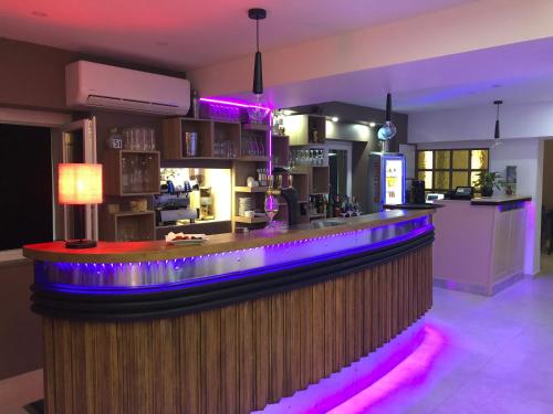 - un bar avec des lumières violettes dans une pièce dans l'établissement belle man, à Longevelle-sur-Doubs