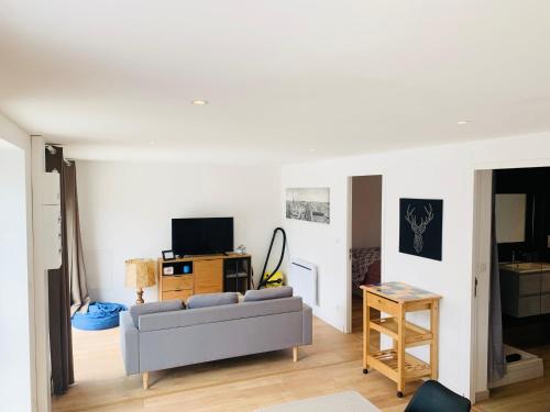 a living room with a couch and a tv at Appartements proches de la mer in Le Relecq-Kerhuon