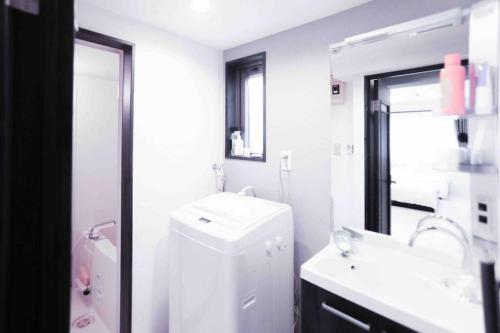 a white bathroom with a sink and a mirror at yuga hotel tokiwadai in Tokyo