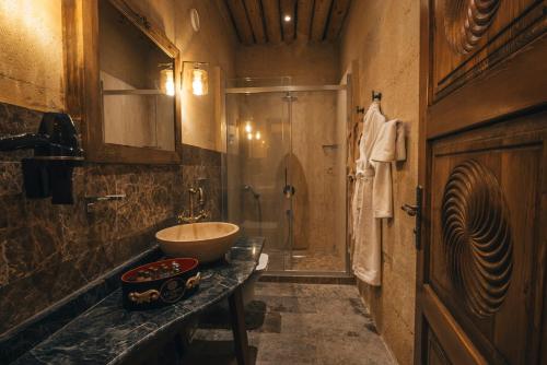 a bathroom with a sink and a toilet and a shower at Harem Suites Cappadocia in Uchisar