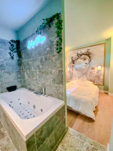 une baignoire dans une pièce avec une statue dans l'établissement L'Antique Plaza, Appartement atypique et unique avec balnéo, proche centre et plage, à Le Portel