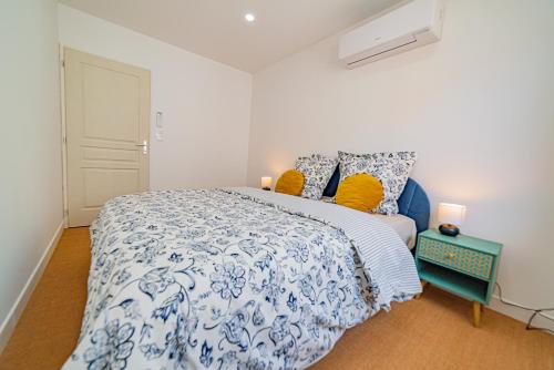 a bedroom with a blue and white bed with yellow pillows at Playroom XXL Loft LOVE Room avec Espace spa Terrasse vue sur les toits Salle de jeux pour adultes Libourne centre 10 min de St Emilion Proche Bordeaux in Libourne