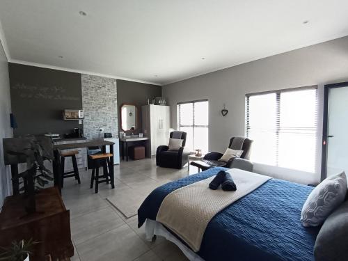 a bedroom with a bed and a living room at Silver Oaks Airbnb in Langebaan