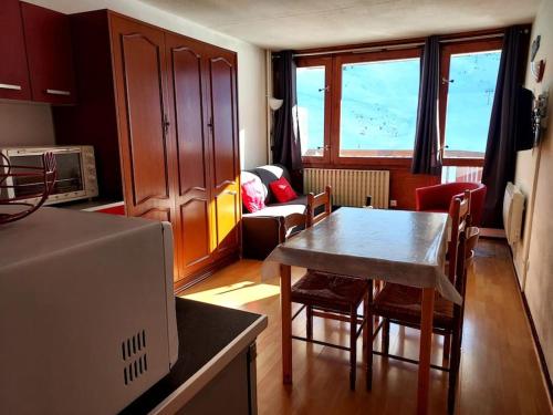 une cuisine avec une table et des chaises dans une pièce dans l'établissement Appartement Station de ski La Mongie Pieds des Pistes 6 couchages, à Bagnères-de-Bigorre