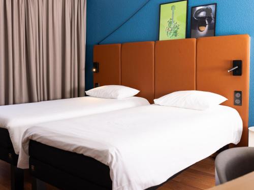 two beds sitting next to each other in a room at ibis Valenciennes in Valenciennes