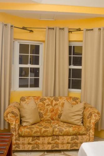 a couch in a living room with two windows at Veronica Villa 68 in Lucea
