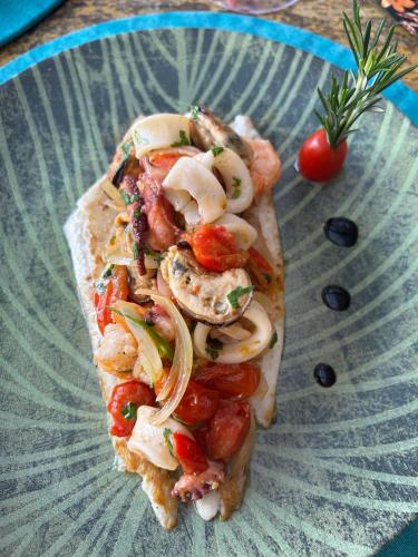 a slice of pizza with mushrooms and tomatoes on a plate at Pousada TeMoana in Ubatuba
