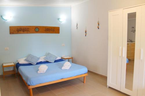 a bedroom with a blue bed with towels on it at S’alba Noa in Quartu SantʼElena