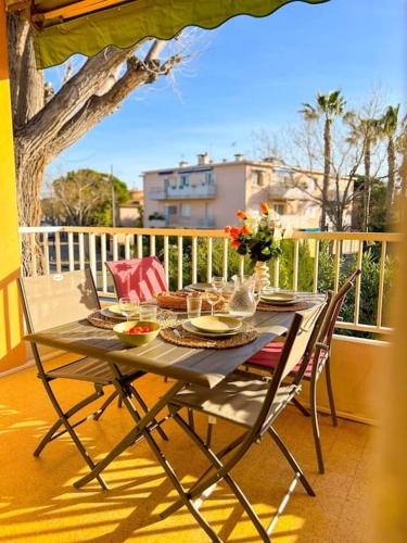 une table et des chaises assises sur un balcon dans l'établissement Joli T2 à deux pas des plages Six-Fours Sanary, à Sanary-sur-Mer