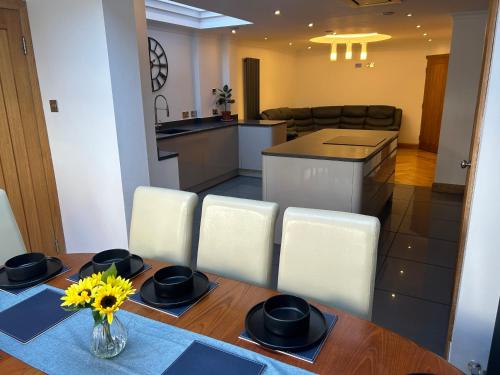 a kitchen and dining room with a table and chairs at Entire Seaside Home 6 Private Bedrooms Sleeps 10 in Wallasey
