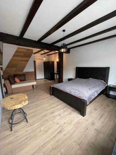 a bedroom with a bed and a couch and a table at Къща за гости ДворЪ in Skandaloto