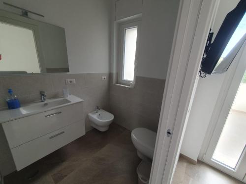 a bathroom with a toilet and a sink and a mirror at L'Acquaviva in Bisceglie
