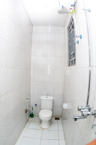 a white bathroom with a toilet and a window at BEZINDA LODGE in Dodoma
