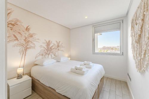 ein Schlafzimmer mit einem Bett mit weißer Bettwäsche und einem Fenster in der Unterkunft Ocean Garden Sunset View in Adeje