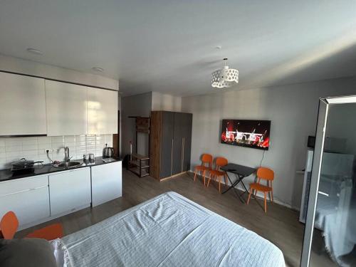 a kitchen with a bed and a kitchen with orange chairs at Студия с бассейном во дворе White Sails in Minda