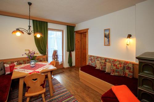 a living room with a table and a bed and a dining room at Biohof-Inntalblick in Kaunerberg