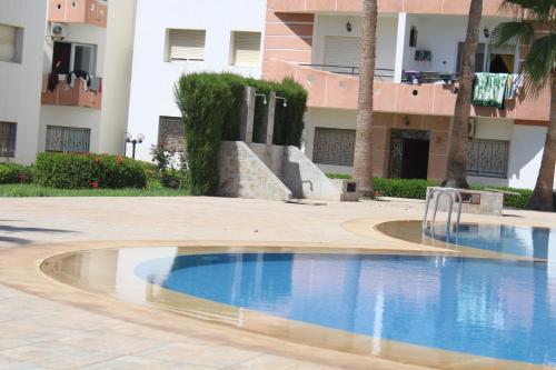 a swimming pool in front of a building at Mohammedia 2 in Mohammedia