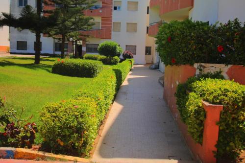 a sidewalk in front of a building with bushes at Mohammedia 2 in Mohammedia