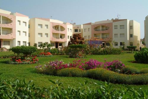 a park with flowers in front of some buildings at Mohammedia 2 in Mohammedia