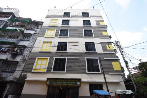 a tall building with yellow and black windows at OYO 82026 BANGUR INN in Nager Bazaar