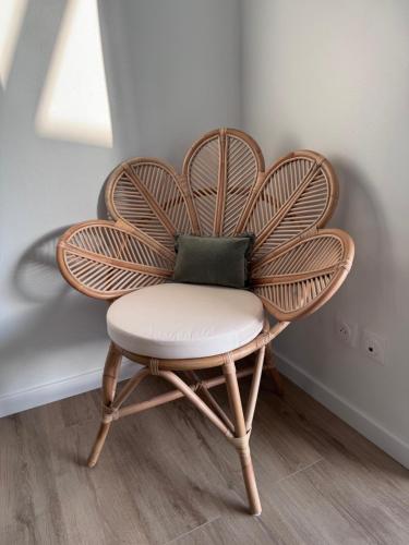 a wicker chair with a pillow in a room at Villa Ô in Les Avirons