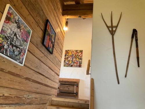 a hallway with wooden walls and stairs with paintings on the wall at Almhaus Chalet 607 - Lachtal in Oberwölz Stadt